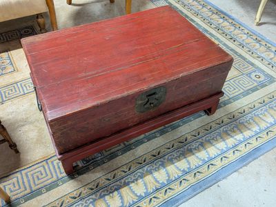 une petite boîte en bois posée sur un tapis, par terre