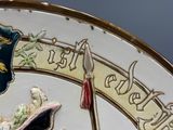 a close up of a decorative plate with a clock on it