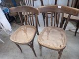 four wooden chairs sitting next to each other in a room