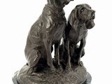 a statue of two dogs sitting on top of a marble base