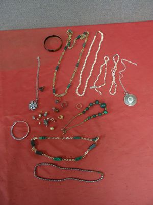 de nombreux bijoux de toutes sortes disposés sur une table rouge