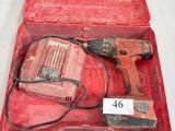 une boîte à outils rouge contenant une perceuse et un marteau