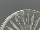 a glass plate with knives on it on a table