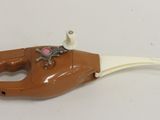 a brown and white toy gun on a white surface
