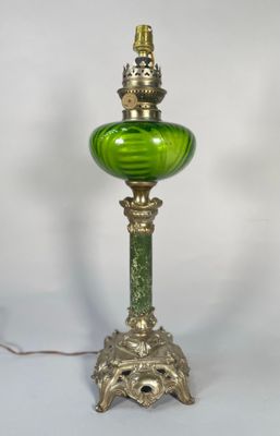 une photo d'une lampe de table en verre vert avec un pied doré