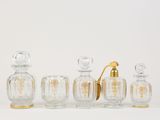 six glass perfume bottles with gold trims and a gold handle