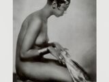 an old black and white photo of a naked woman sitting on the ground