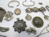 many different types of silver jewelry on a table