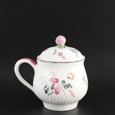 une image représentant une théière blanche ornée de fleurs roses