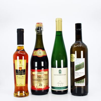 four bottles of wine are lined up on a white surface