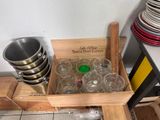 a wooden box filled with empty glasses and a green lid
