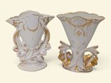 two white vases with gold designs on them