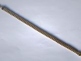 a close up of a metal bracelet on a white surface