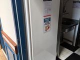a white refrigerator in a kitchen with a black and white checkered floor