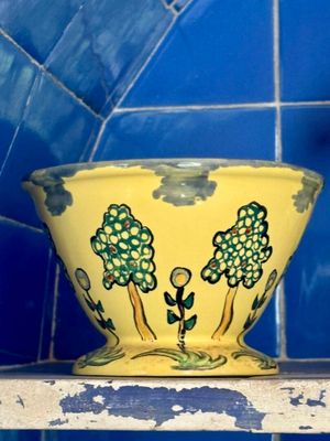 un bol jaune posé sur une étagère dans une pièce carrelée de bleu