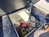 a person standing on the deck of a boat with a cooler in it