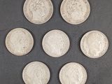 six pièces de monnaie britanniques différentes sont disposées en cercle sur une surface noire