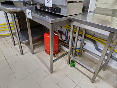 une cuisine avec de nombreux plans de travail en inox et une borne d'incendie rouge