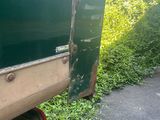 a green truck that is parked on the side of the road