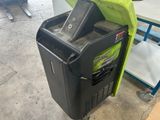 a black trash can with a green cover on top of it