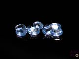 a pair of blue topazte gems on a black surface