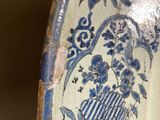 a blue and white vase with a bird and flowers on it