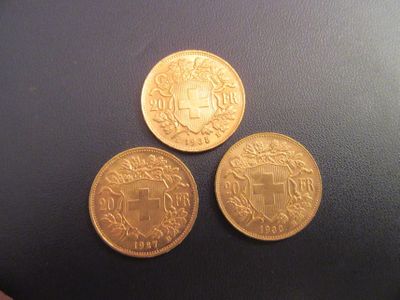 trois pièces d'or posées les unes à côté des autres sur une table