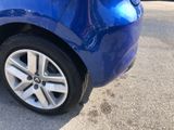 a close up of a blue car that is parked in a parking lot