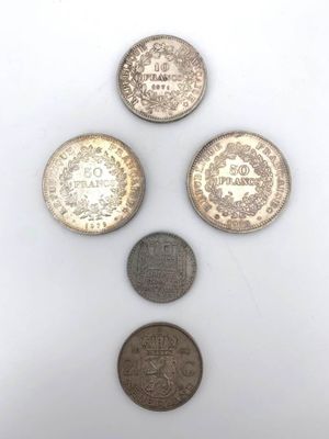 four different types of coins sitting on top of a white surface