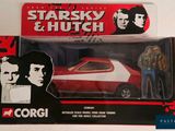 a red and white toy car with a man standing next to it
