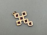 a close up of a gold cross on a gray surface