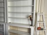 a white bookcase with a ladder next to a bed