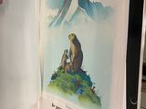 une personne tenant un livre ouvert sur lequel figure l'image d'un ours