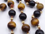 necklace made of tiger eye beads with gold accents on a white background