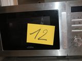 un micro-ondes posé sur une table, sur laquelle est collé un autocollant jaune