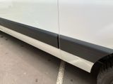 a white van with a black stripe parked in a parking lot