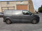 the grey van is parked in the parking lot next to the building