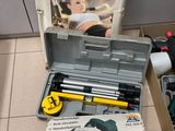 une boîte à outils contenant des outils, posée sur le sol