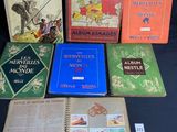 Plusieurs livres sont alignés sur une table devant un fond noir.