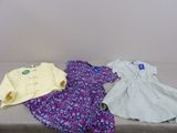 deux robes et une chemise posées sur un lit