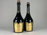 deux bouteilles de vin noir et doré posées sur une table