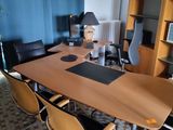 tables and chairs in a room with a bookcase and a lamp