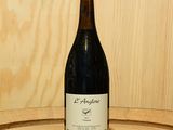 une bouteille de vin posée sur un tonneau en bois