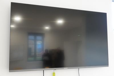 un téléviseur à écran plat fixé au mur d'une pièce