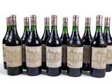 six bottles of wine are lined up in a row on a white surface