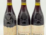 trois bouteilles de vin posées les unes à côté des autres sur une surface blanche