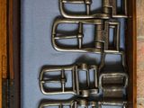 a bunch of metal buckles in a wooden case