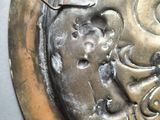 a close up of a metal plate with a skull on it