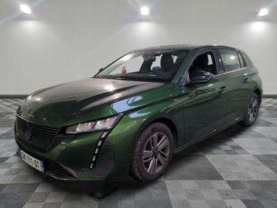 the green car is parked on a checkered floor in the garage
