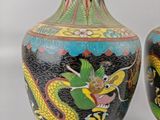 two vases with dragon designs on them sitting on a table